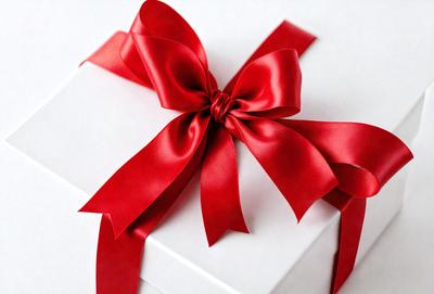 The primary subject of the image is a red bow, which is tied around a white box. The setting is a white background, and the visual style is a photo. The red bow and white box create a bold and eye-catching color combination, evoking a sense of warmth and festivity.